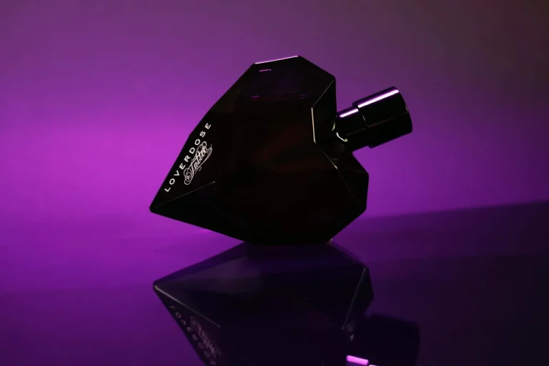 Širdies formos kvepalų buteliukas violetinėje šviesoje