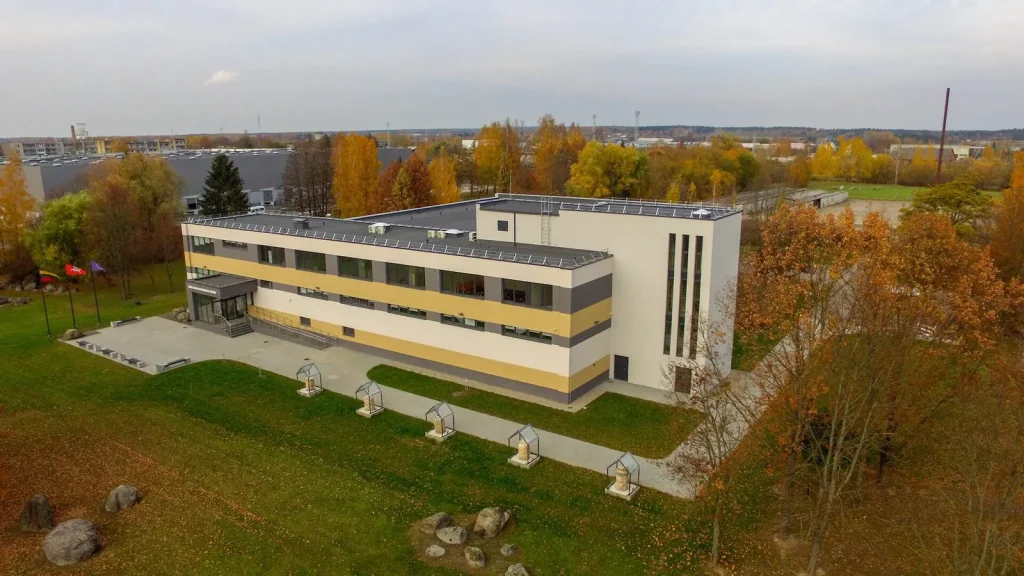 Dviejų aukštų pastatas ir rudens medžiai, iš drono