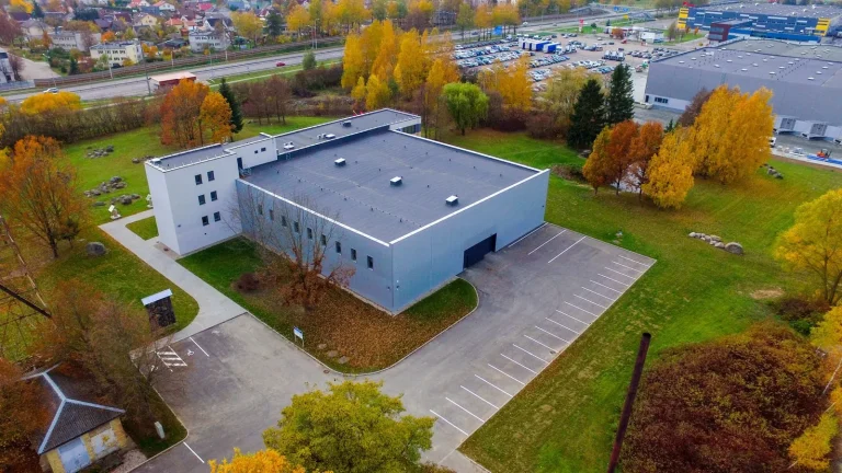Pastatas ir kiemas tarp rudens medžių, iš drono